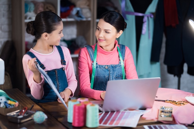 Little girl shows an adult woman a clothing scheme