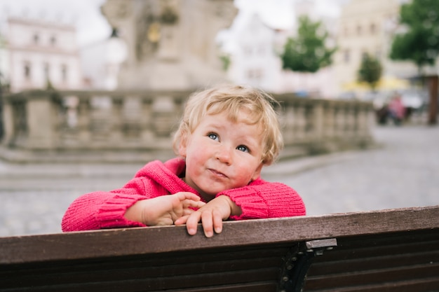 Little girl sitting on bench