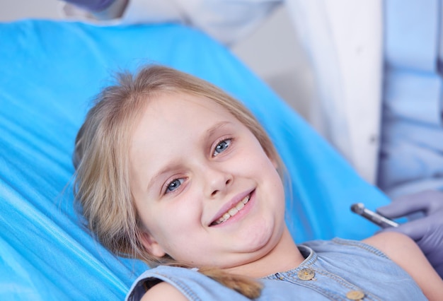 Little girl sitting in the dentists office