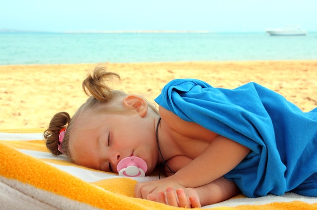 Little girl sleeping on beach