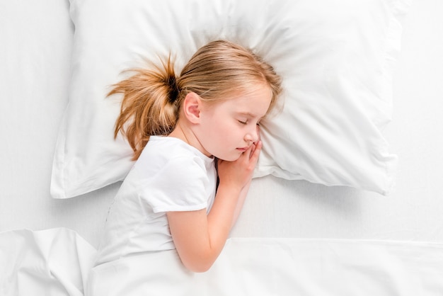 Photo little girl sleeping in white bed