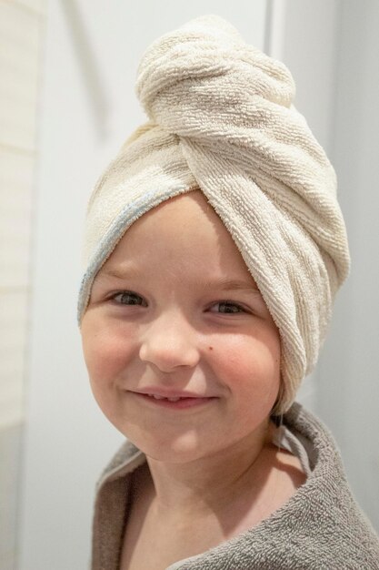 Little girl smiling wrapped in bath towel and towel