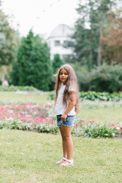 Little girl spends her summer holidays in nature walking in the park