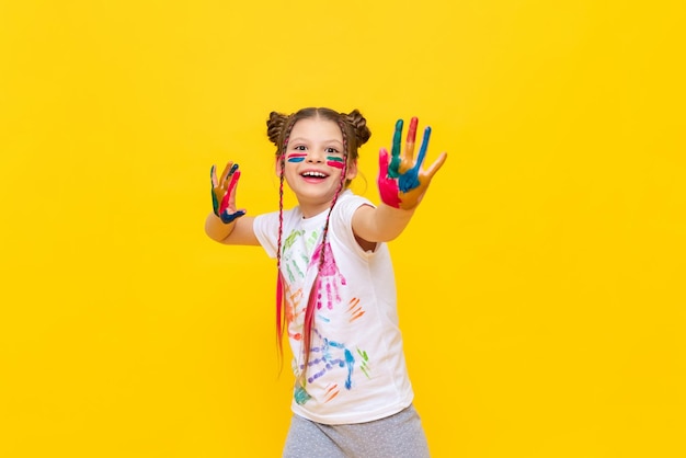 A little girl stained in multicolored paints is fooling around Children's creativity drawing Draw with your hands The art of creating paintings for schoolchildren