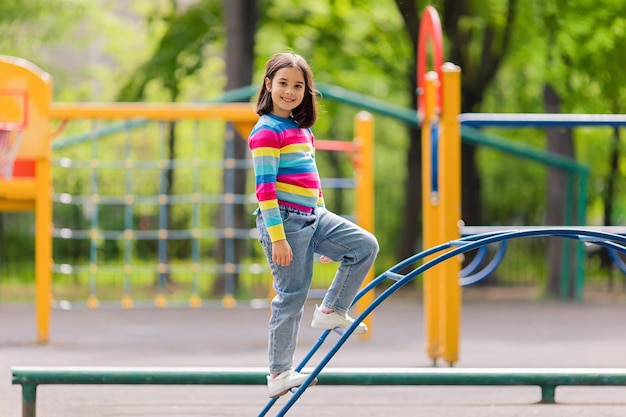 A little girl stand on the childrens stairs on the playground