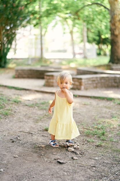 Little girl standing on the ground in the park