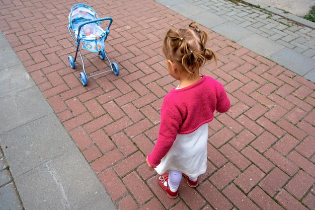 Little girl and stroller for doll