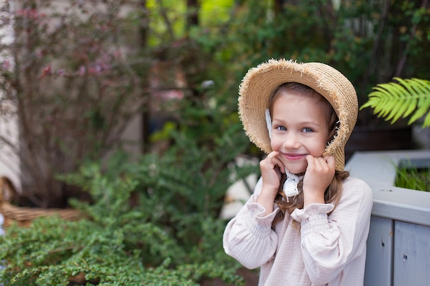 A little girl in a summer dress stands on a wooden bridge in the park An image with selective focusing noise effects and toning Focus on the girl