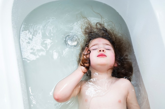 Little girl swimming in the bathroom 