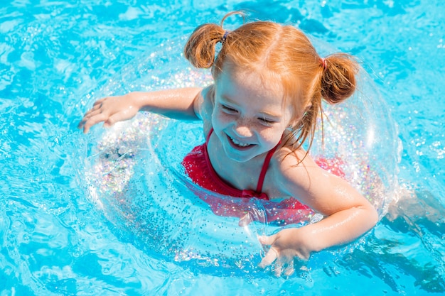 Little girl swimming in the pool in summer