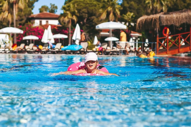 Little girl swimming with floating ring in the pool