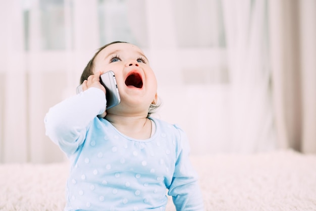 A little girl talking on a smartphone smiling and happy very sweet