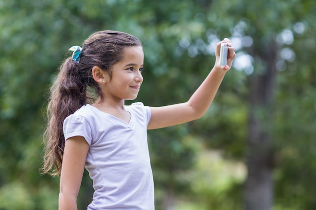 Little girl using her phone on a sunny day