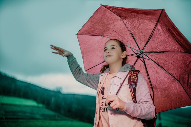 Little girl waiting for bus on rain day