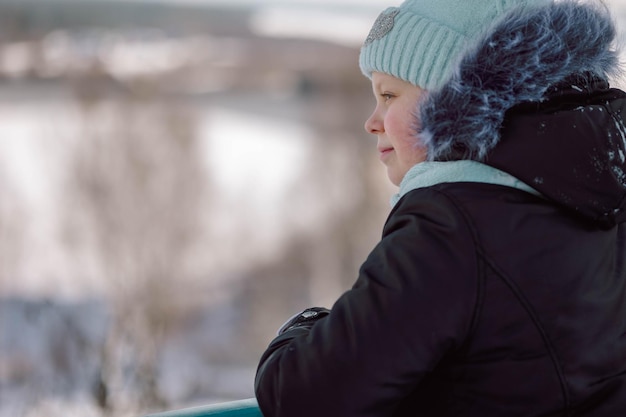 Little girl walks outdoors on winter snowy day in