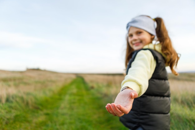 A little girl walks a path holding a guy's hand