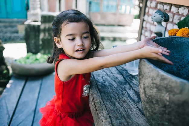 Little girl washing hands in sink outdoors