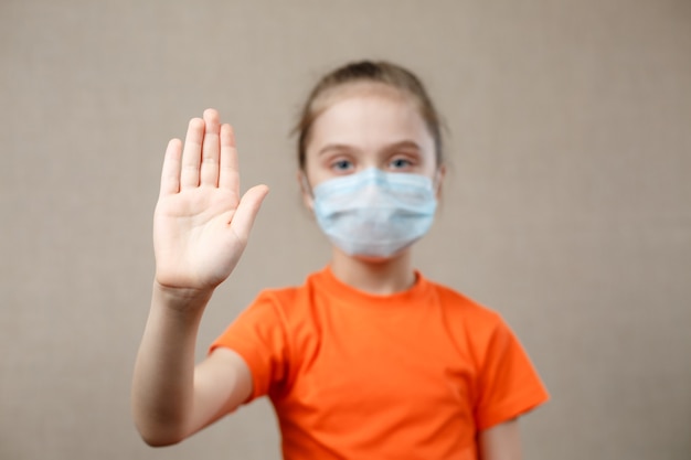 Little Girl Wearing Mask For Protect. Showing Stop Sign. Stop The Virus And Epidemic Diseases. Coronavirus Covid-19.Stay At Home Stay Safe Concept. Selective Focus on Hand.