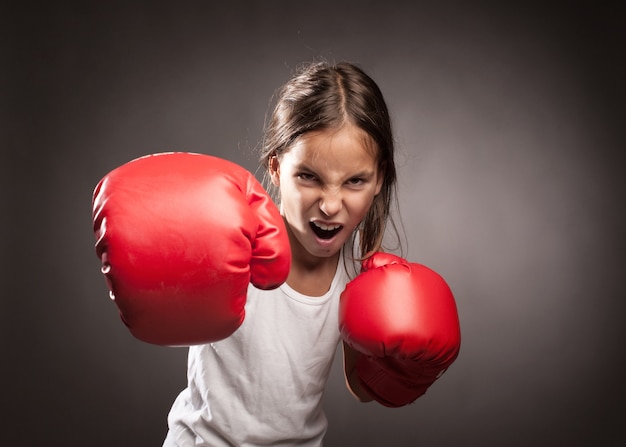 little girl wearing red boxing gloves