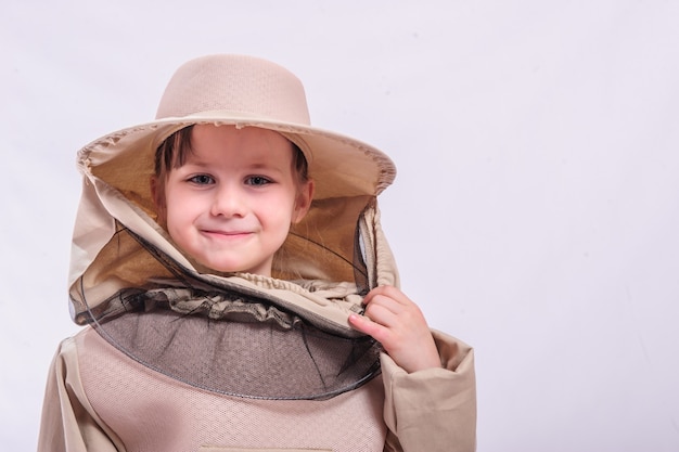 A little girl wears an over sized bee suit in studio white background.