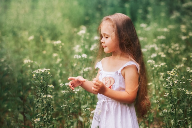 little girl in a white dress on a summer meadow