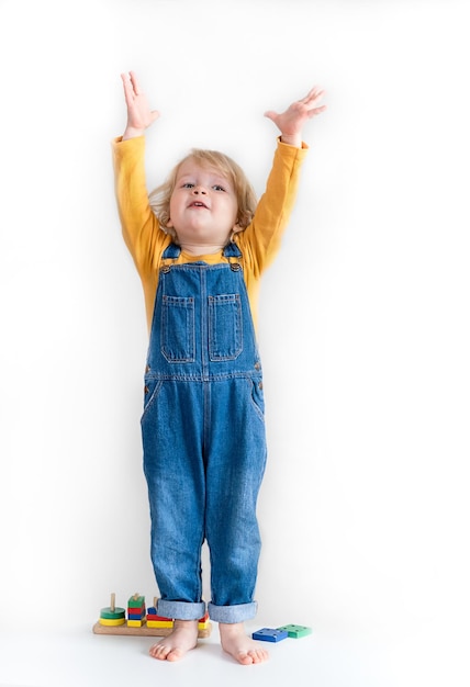 Little girl in a white tshirt points to an empty space near her layout for design vertical foto