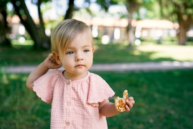 Little girl with a bitten pancake in her hand