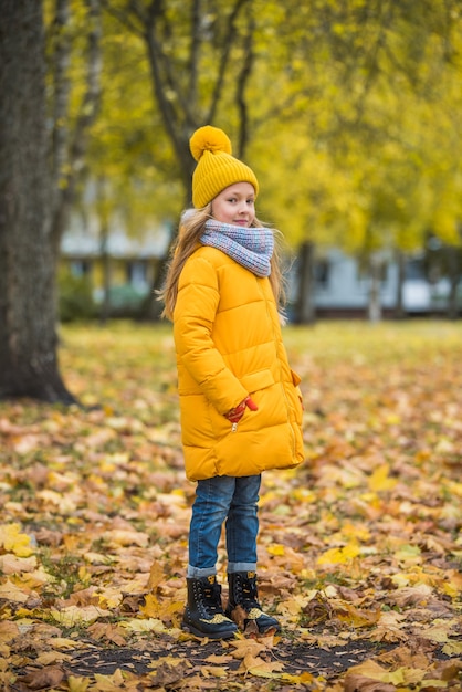 Little girl with blond hair in autumn park