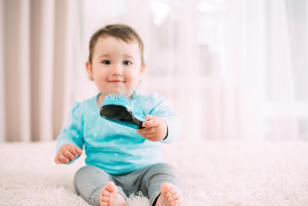 Little girl with a blue comb in a blue jacket on the bed very sweet