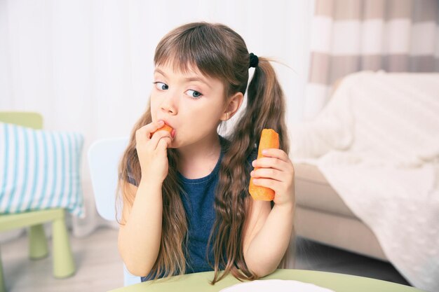 Little girl with carrot in the living room