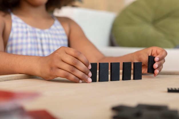 Little girl with curly hair playing with domino pieces