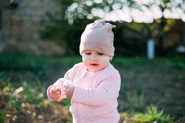 A little girl with a dandelion in her hands having fun