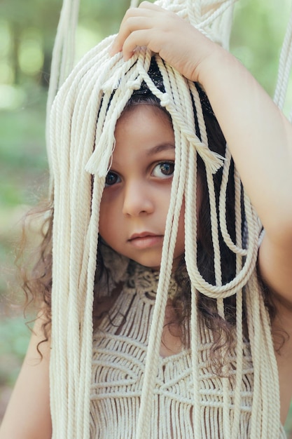 Little girl with dark curly hair dressed as a native in the forest