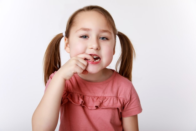 Little girl with the first swinging baby tooth