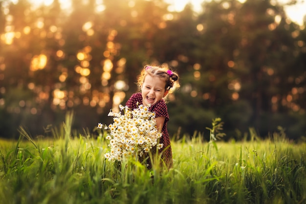 little girl with flowers on nature in summer