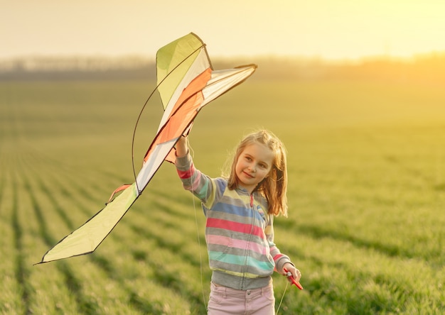 Photo little girl with flying kite