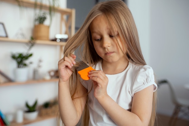 Little girl with head lices taking care of her hair