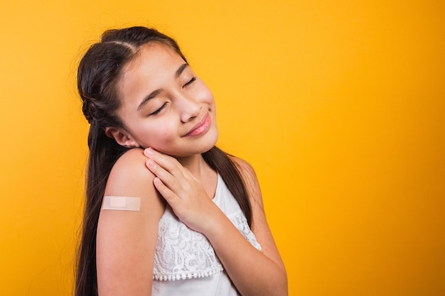 Little girl with her eyes closed smiling after receiving a vaccination.