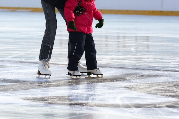 Little girl with mother skate on the rink