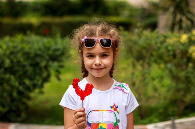 Little girl with red caramel lollipop cockerel