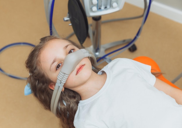 Little girl with sedation mask Treatment of children's teeth with nitrous oxide children's dentistry