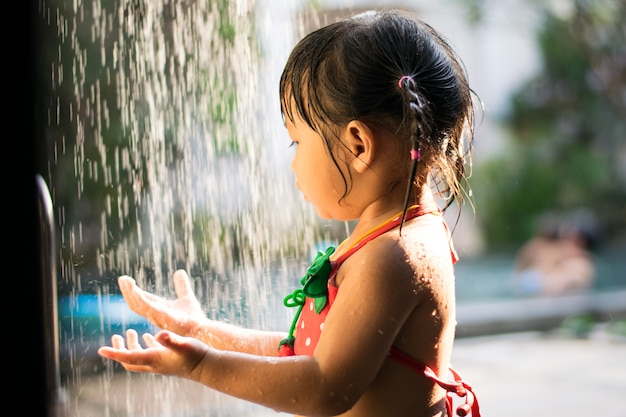 Little girl with shower head outdoor for swimming