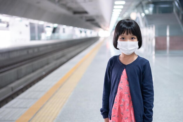 Little girl with surgical mask face protection flu and Virus outbreak in public transportation