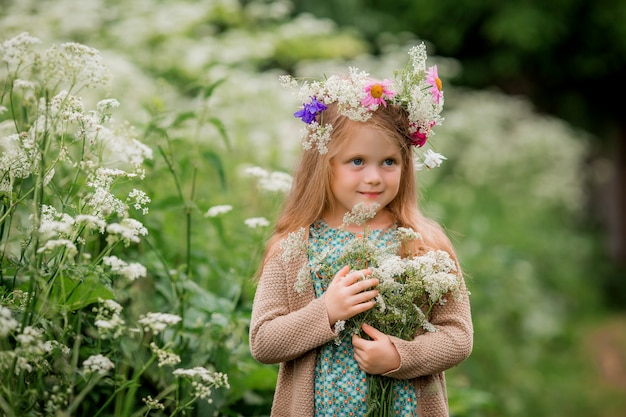 little girl with a wreath of flowers on her head for a walk