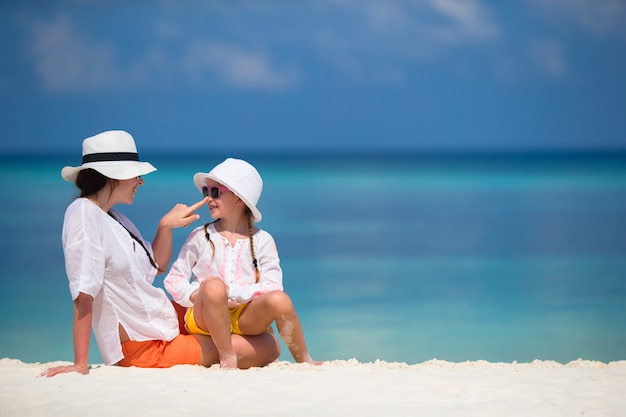 Little girl and young mother during beach vacation