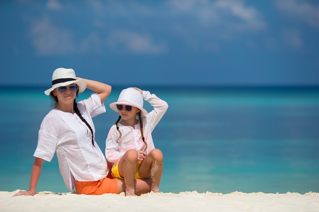 Little girl and young mother during beach vacation