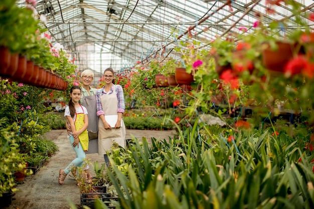 Little girl, young woman and senior woman  in the flower garden