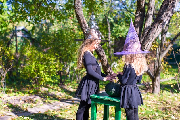 Little girls casting a spell on Halloween in witch costume