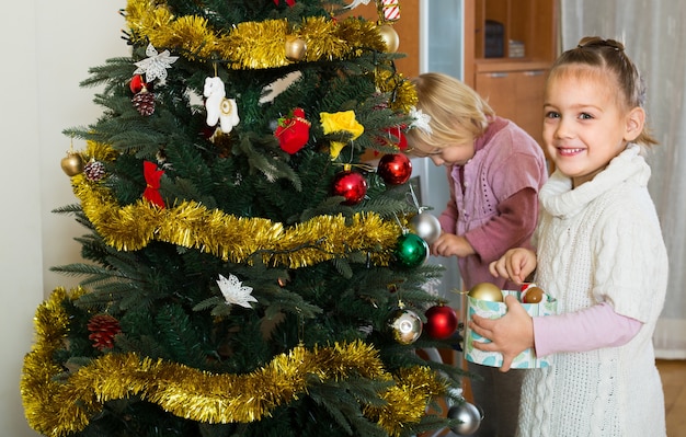 Little girls decorating Christmas tree