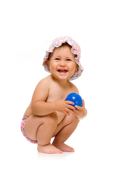 Little happy child in sunhat with ball, isolated over white